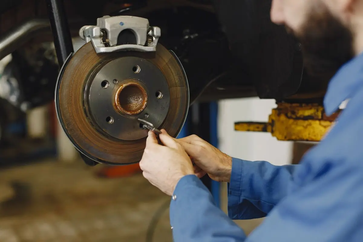Técnico revisando el sistema de frenos de un auto en el taller